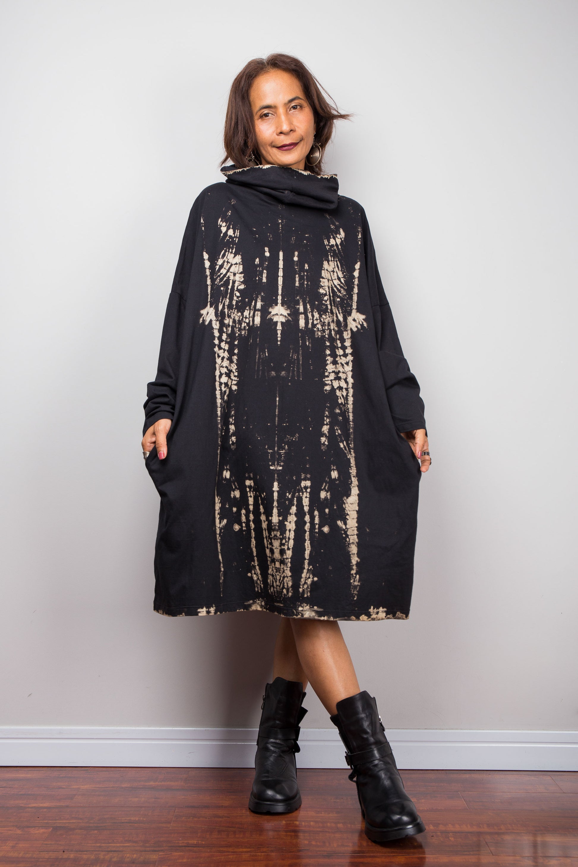 Oversized Nuichan reverse tie dye tunic dress featuring a cowl neck and vertical abstract sand and black patterns. Front view showing two side pockets and long sleeves.