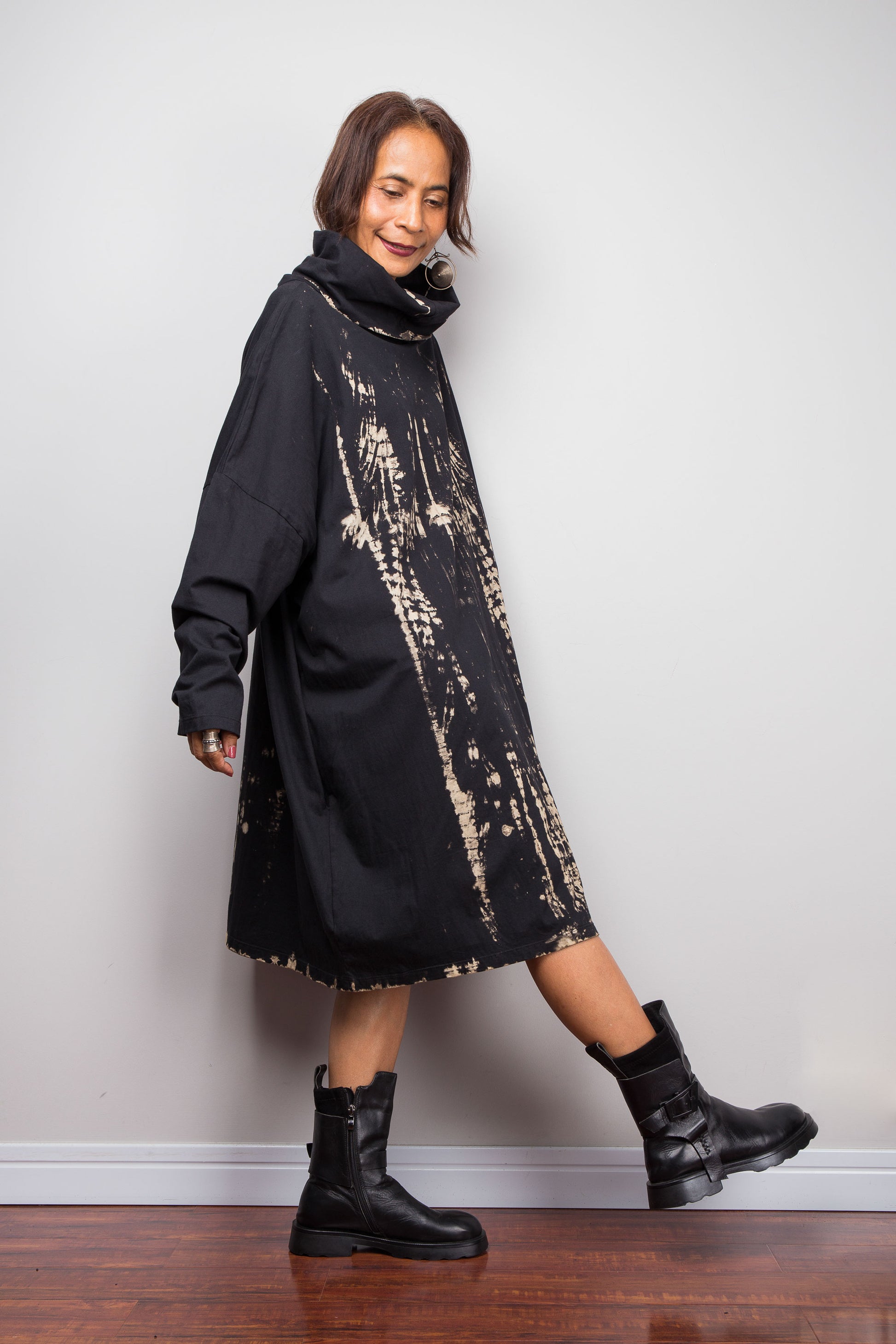 Oversized Nuichan reverse tie dye tunic dress featuring a cowl neck and vertical abstract sand and black patterns.  Highlighting the width at the bottom of the tunic.