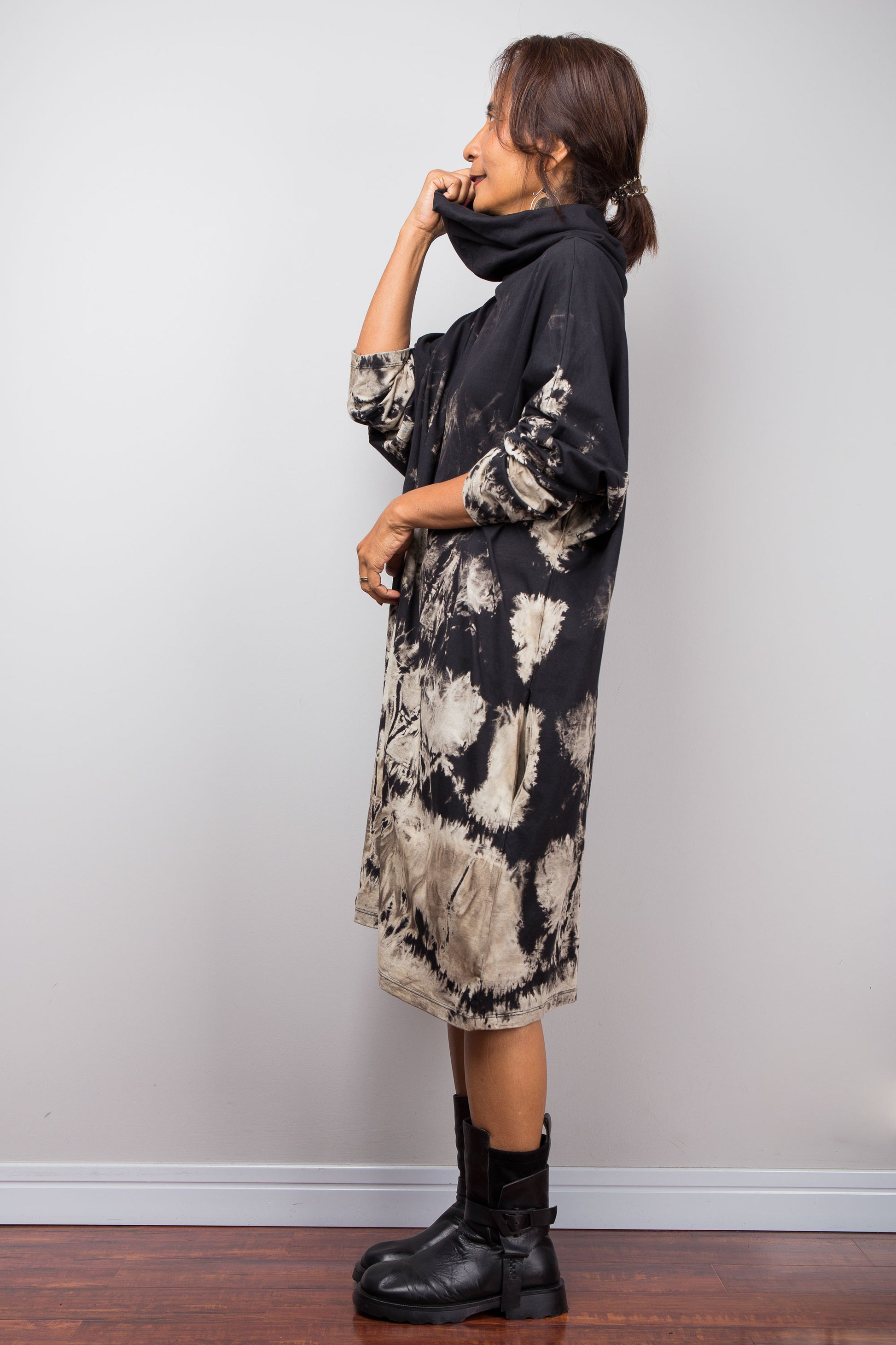 Profile view of a model in the Nuichan bleach dye sweatshirt dress, showcasing the slouchy cowl neck design and loose unstructured midi drape.