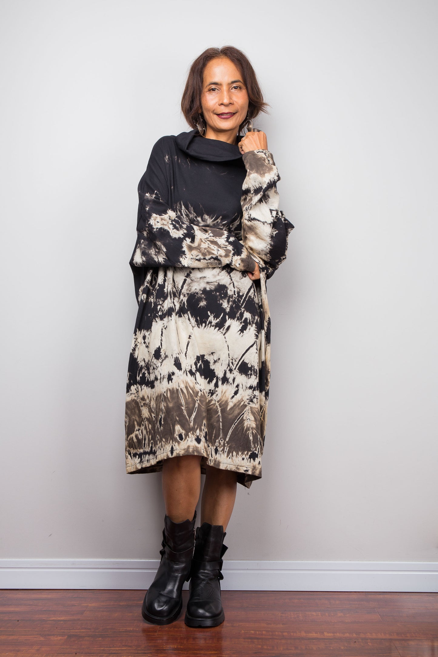 Petite women wearing an Oversized Nuichan reverse tie-dye tunic dress featuring a funnel cowl neck and abstract sand and black patterns.  Front view