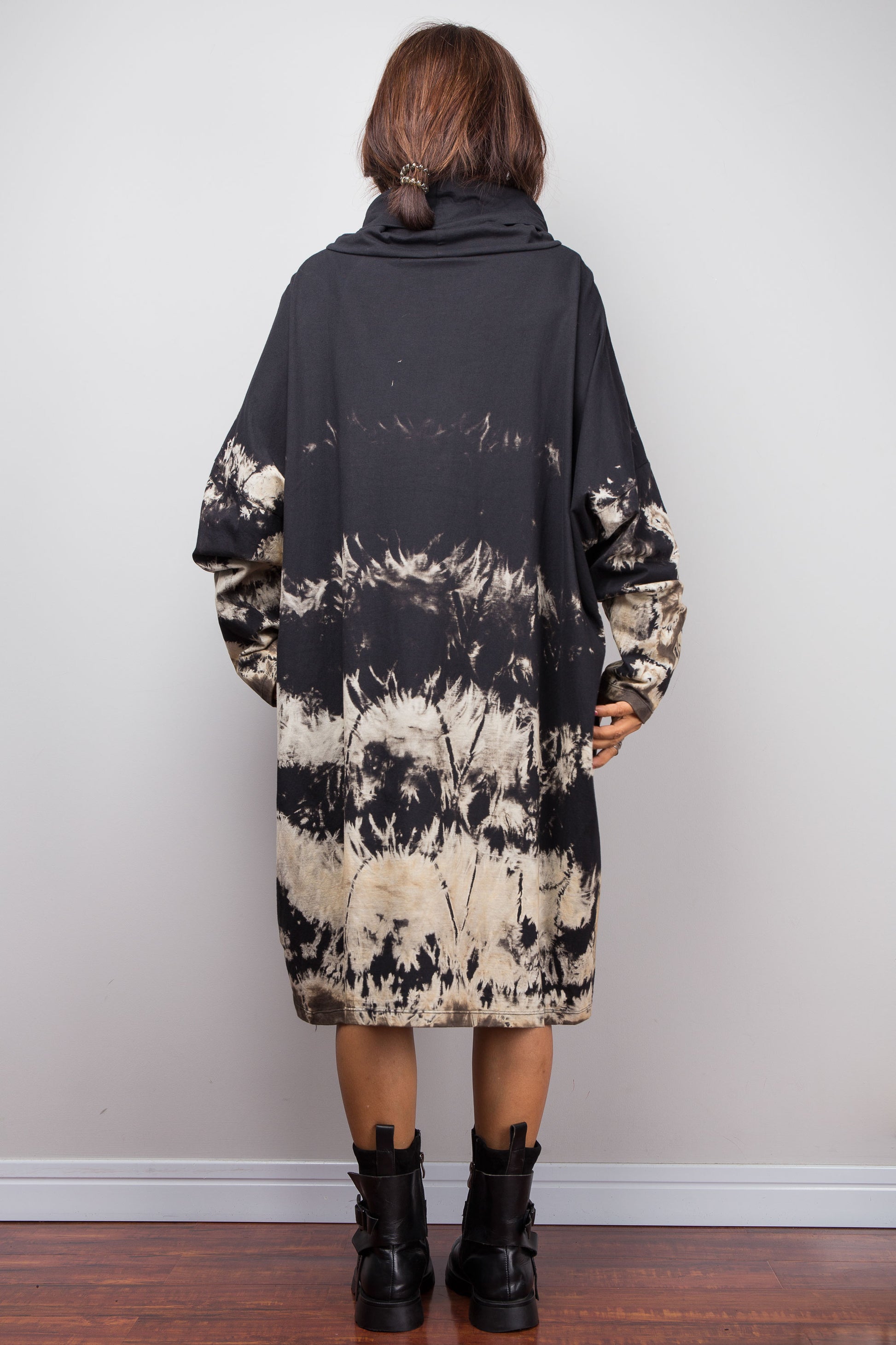 Petite women wearing an Oversized Nuichan reverse tie-dye tunic dress featuring a funnel cowl neck and abstract sand and black patterns.  Rear view 