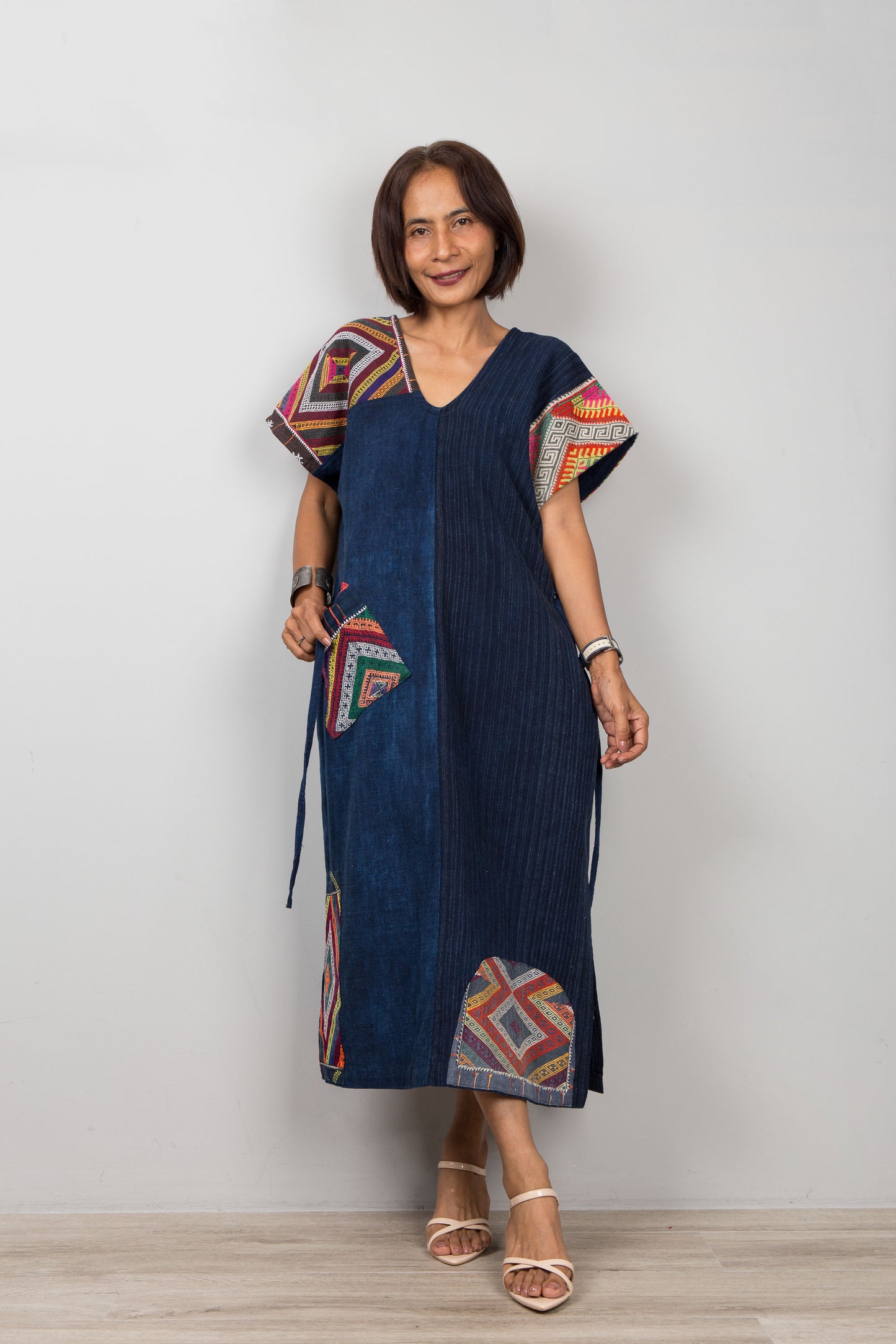 Nuichan wearing a blue dress with colorful patterns on a white background
