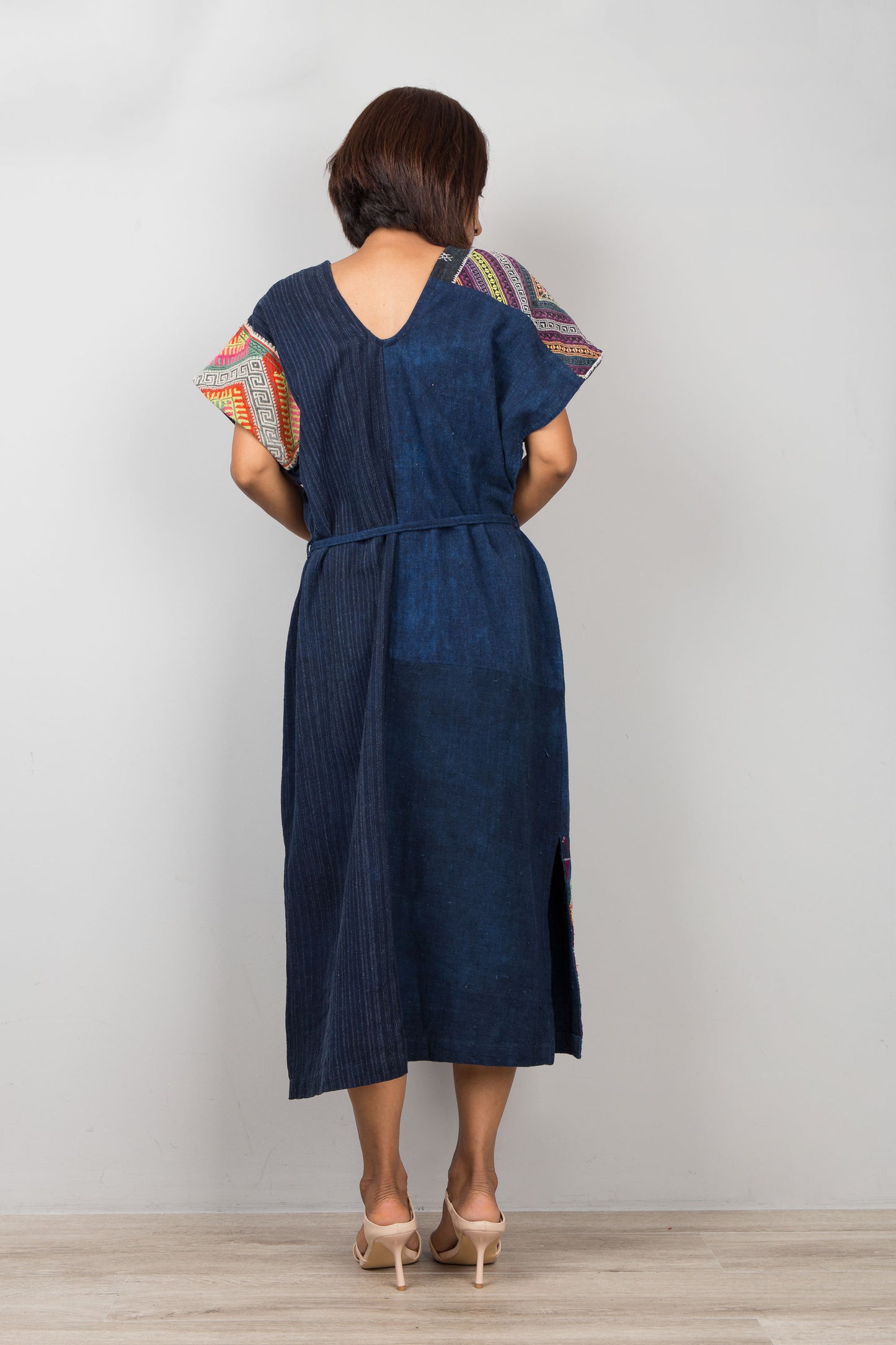 Nuichan wearing a blue cotton patchwork midi dress with colorful sleeves against a white background