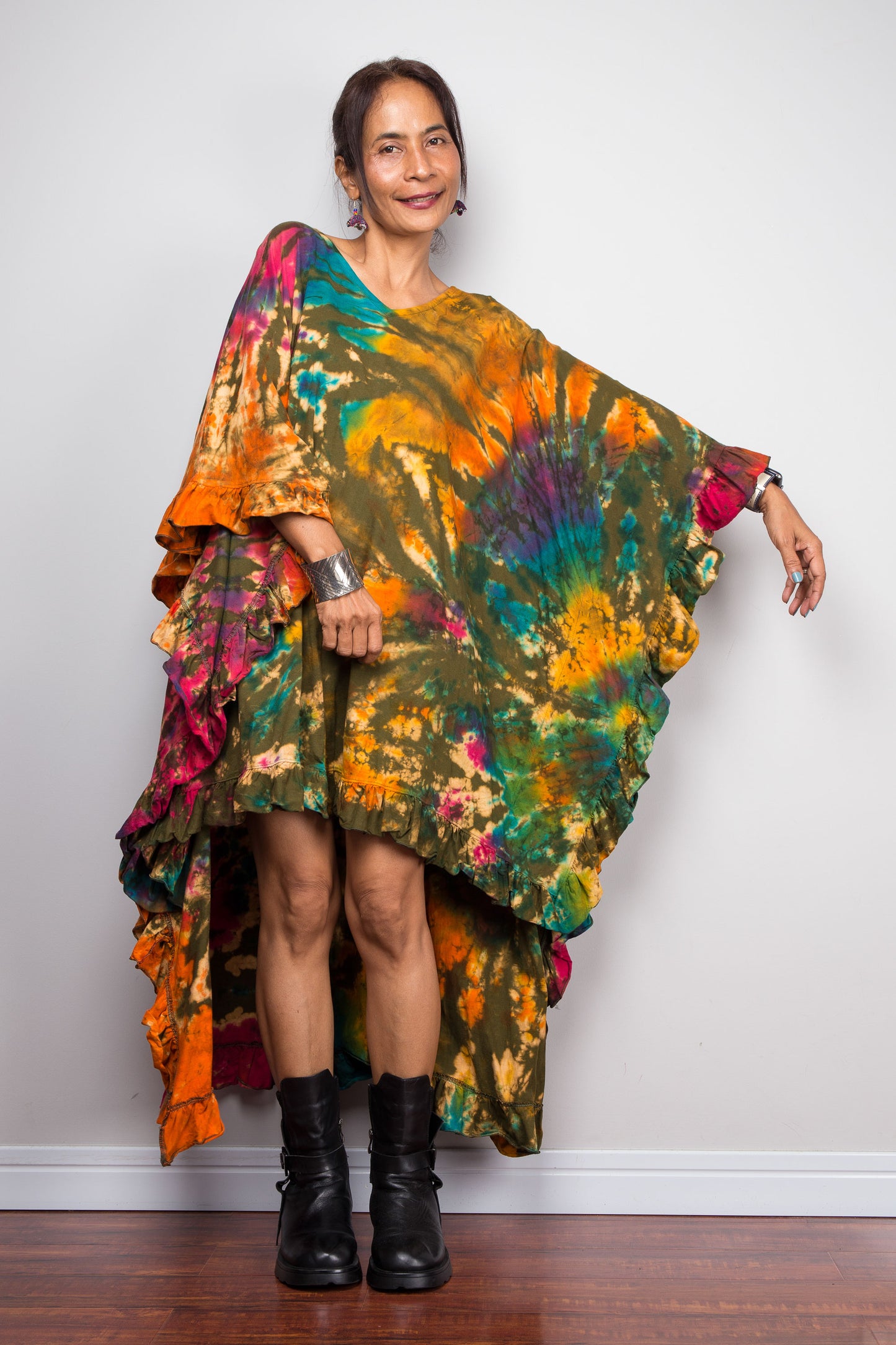 Woman wearing a colorful tie dye kaftan tunic top dress against a plain background
