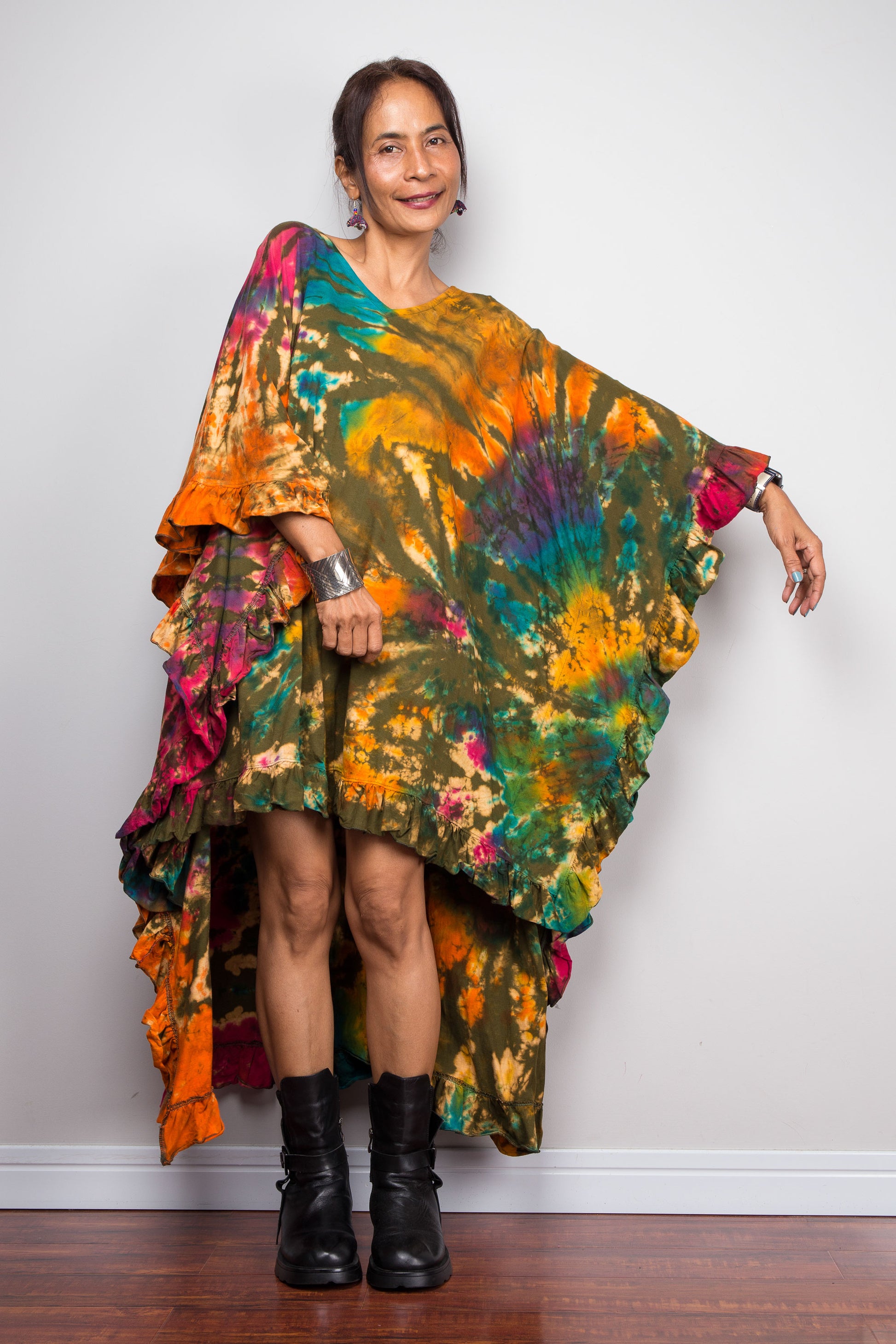 Woman wearing a colorful tie dye kaftan tunic top dress against a plain background
