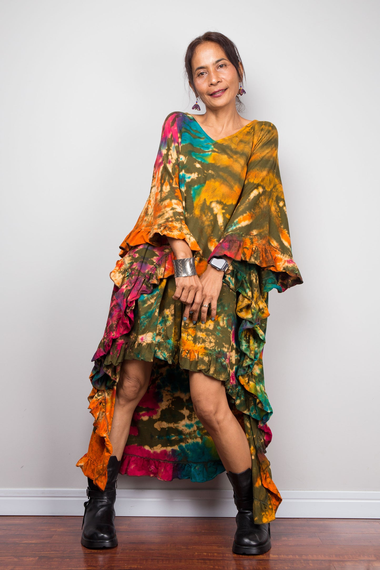 Woman wearing a colorful, patterned tie dye caftan tunic by Nuichan with a plain background