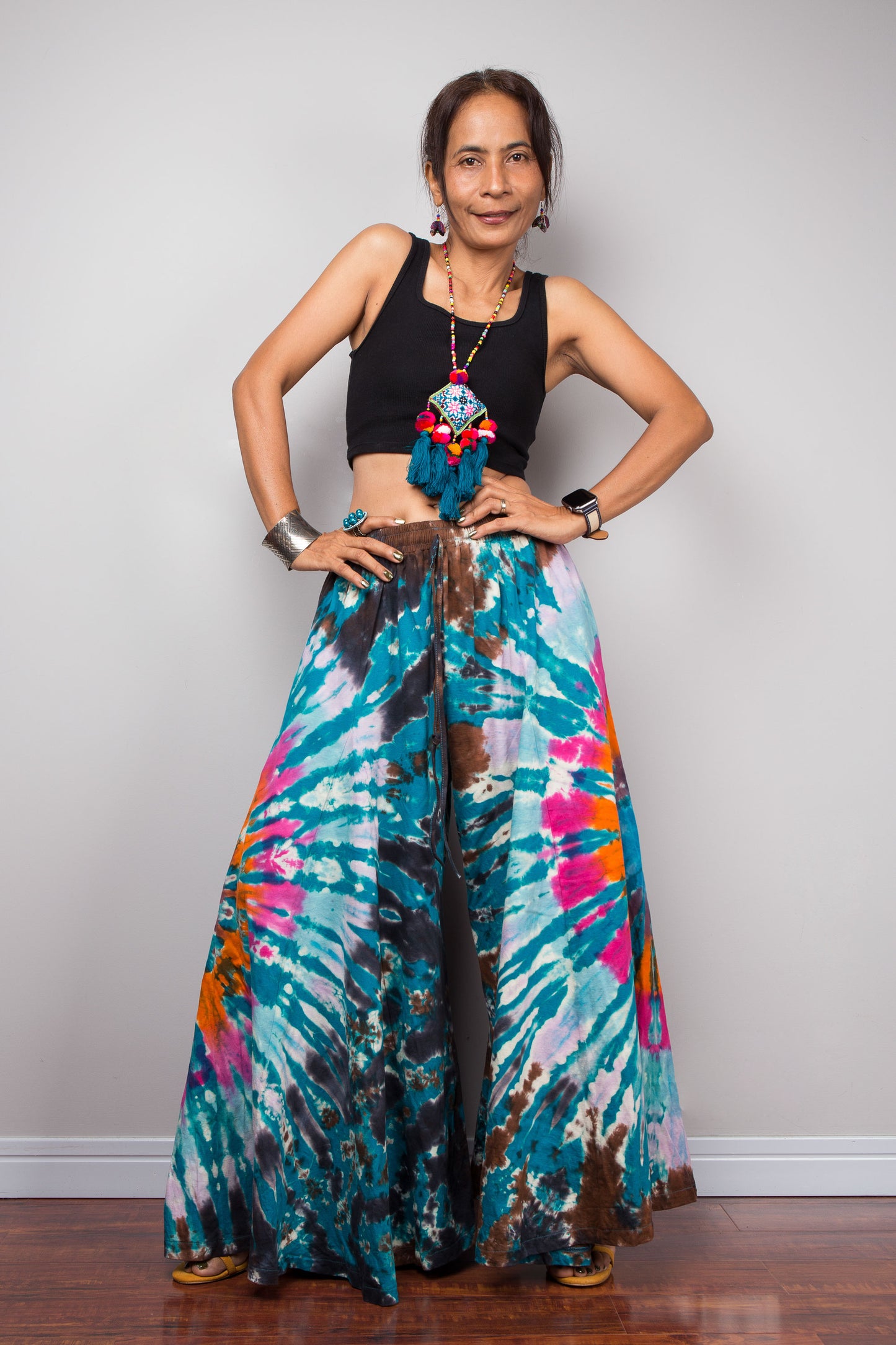 Full-length front view of a petite model in the Nuichan multicolour tie dye wide leg palazzo pants, illustrating how the unstructured ultra-wide cotton legs mimic the elegant sweeping flow of a maxi skirt from waist to floor