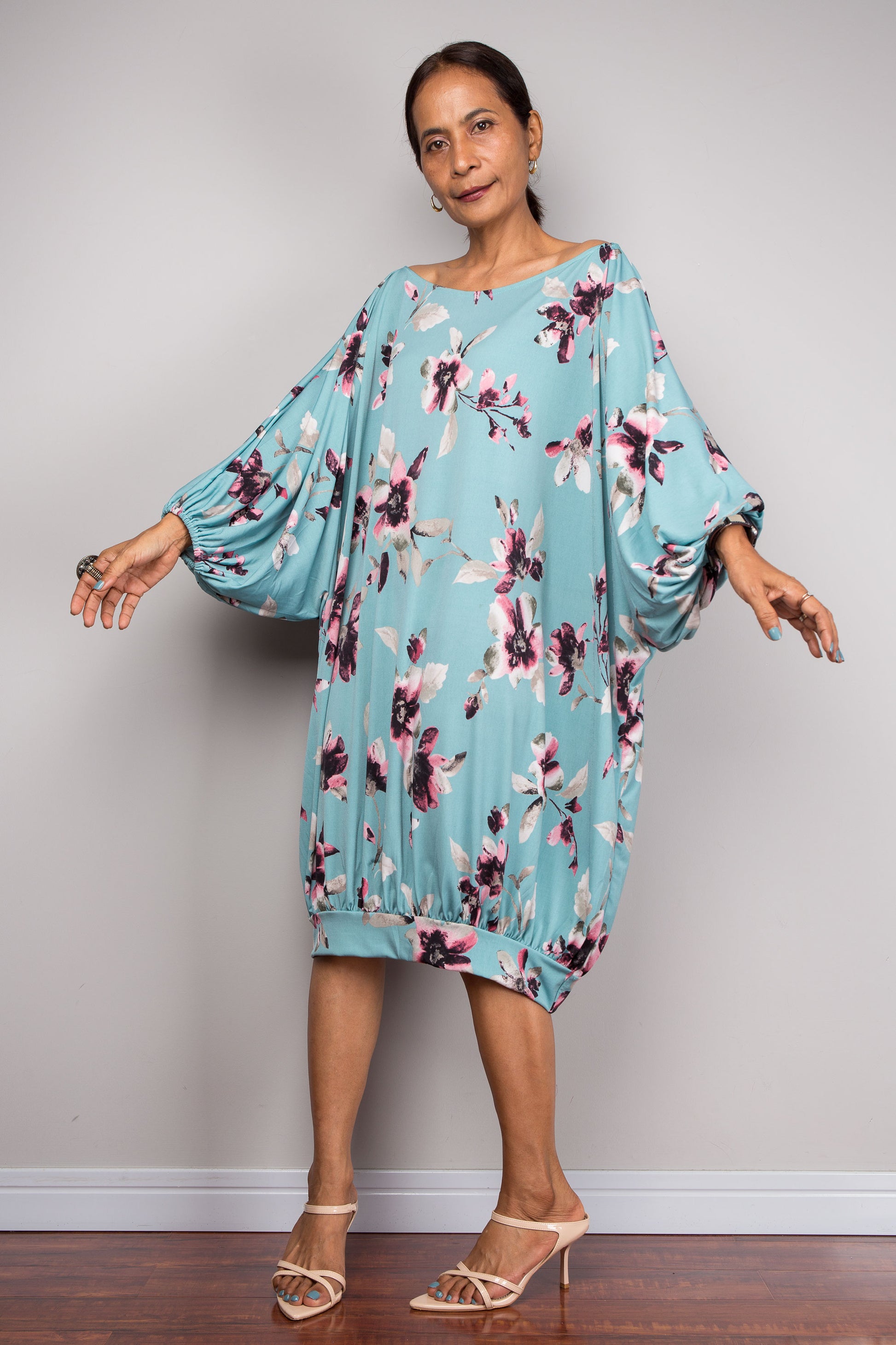 Petite Woman wearing a light blue floral kaftan dress against a plain background