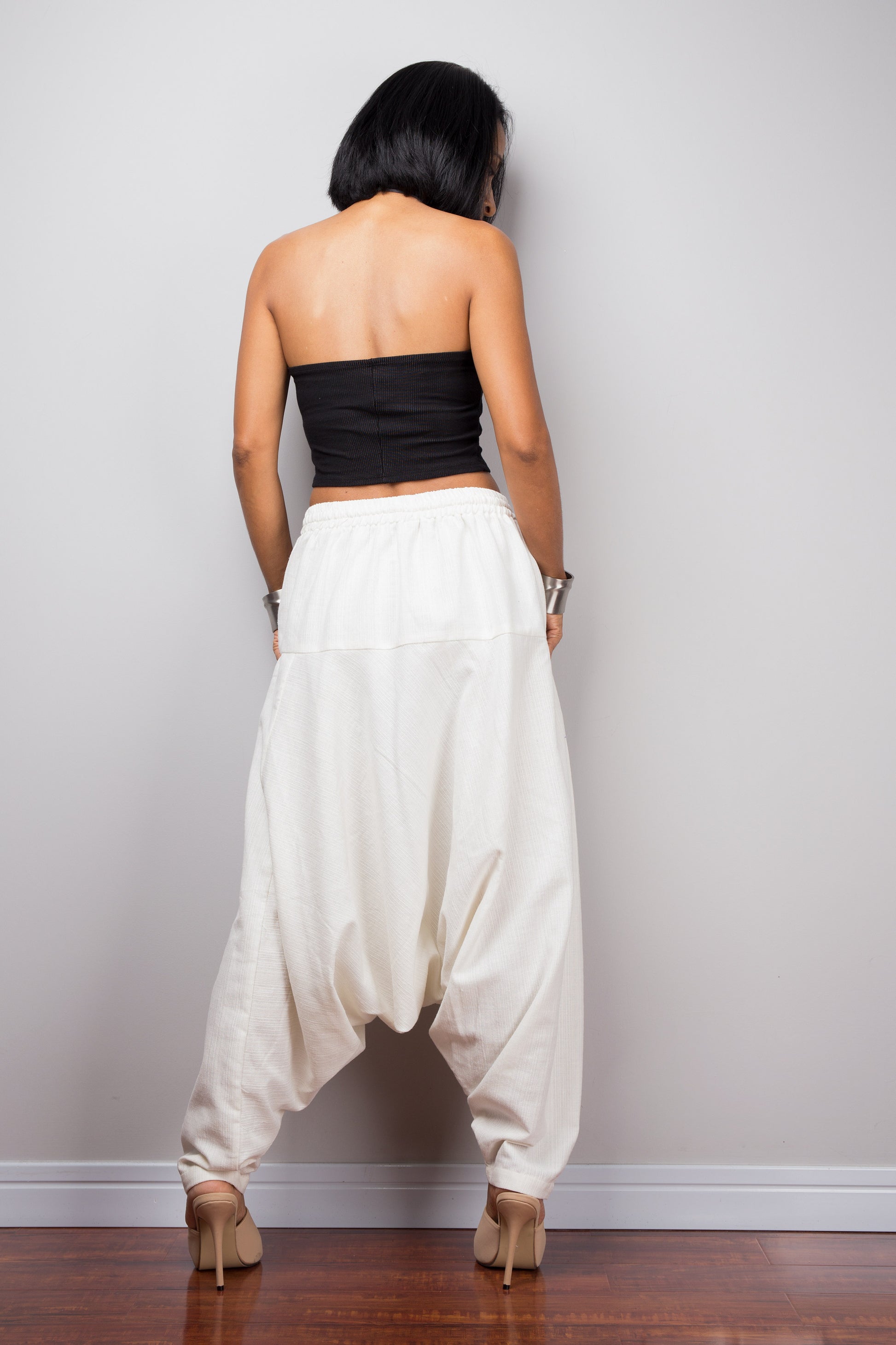 Back view of the model in white harem pants, showing how the pants drape and the fit around the hips.