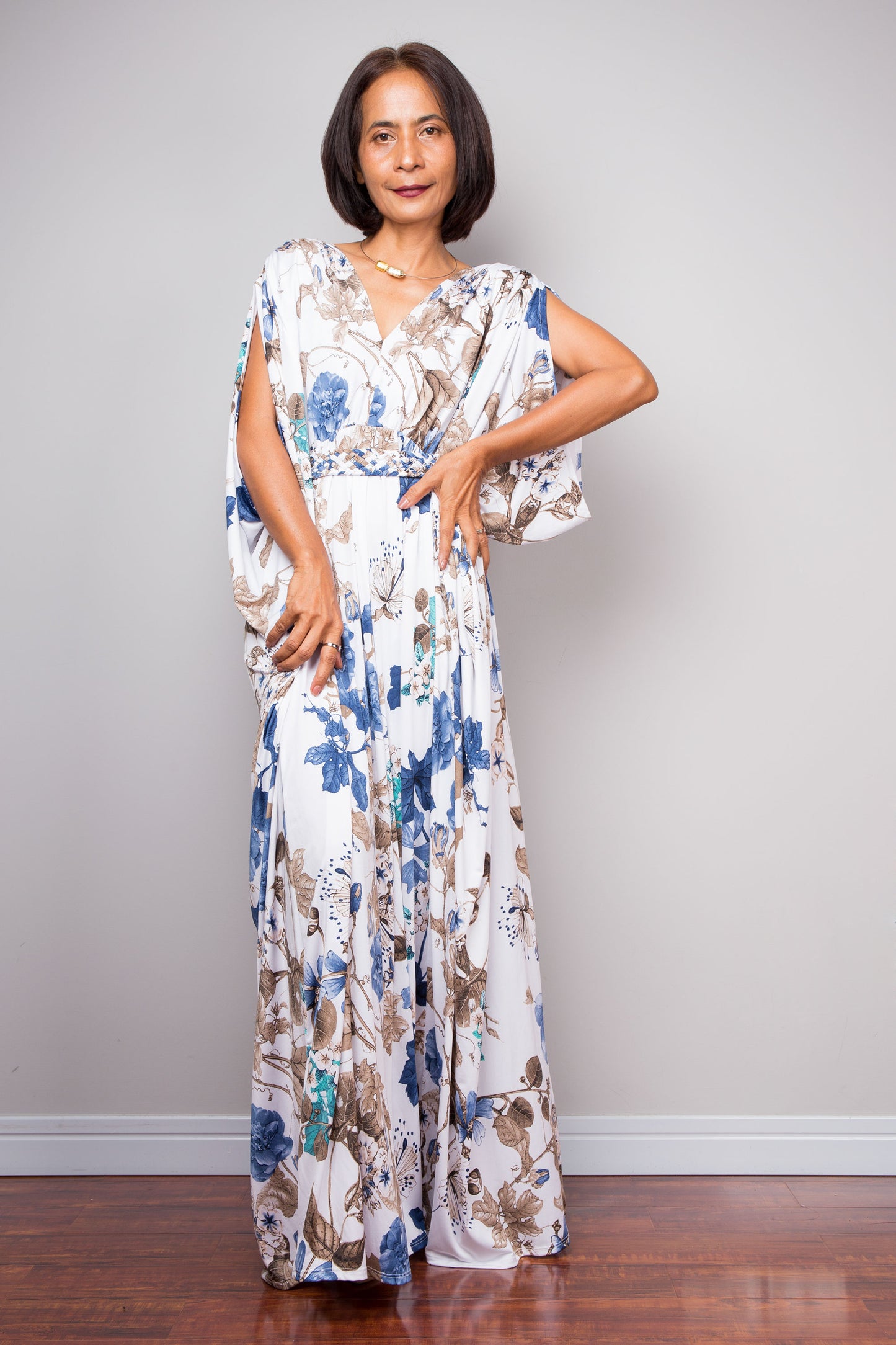 Loose fit floral maxi dress in blue, teal, and brown on white background.