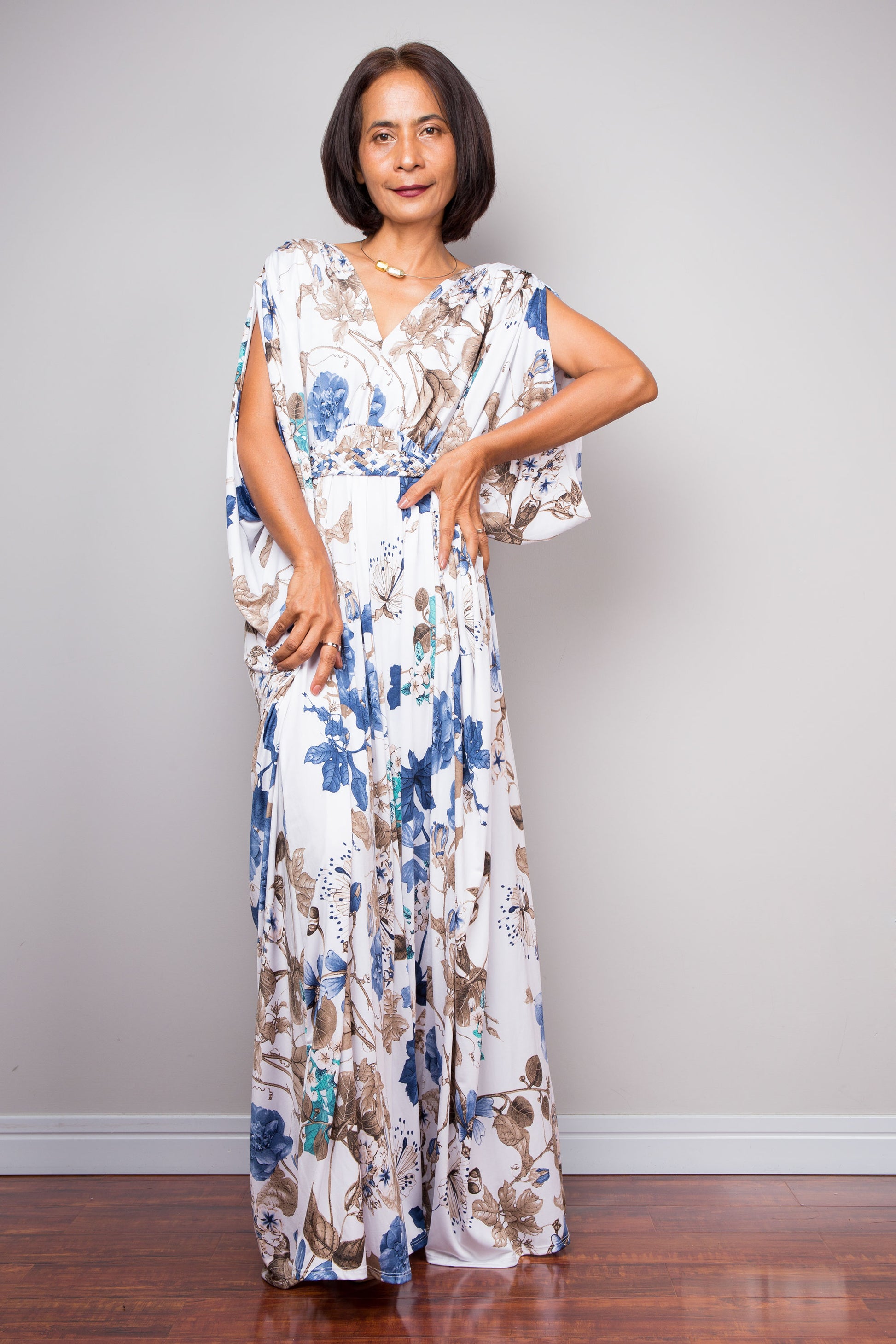 Loose fit floral maxi dress in blue, teal, and brown on white background.