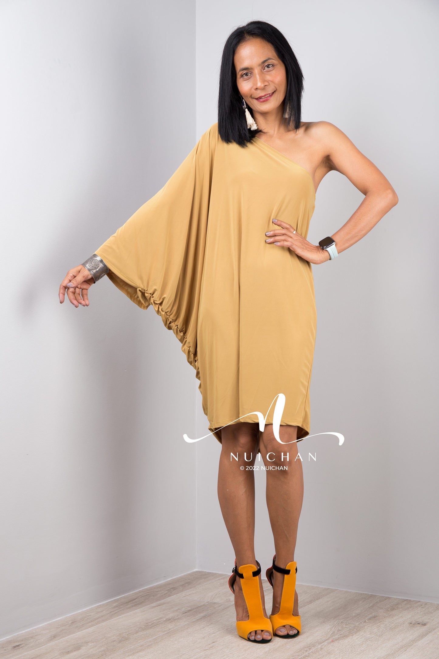 A sexy mustard yellow off shoulder dress for women. Short one shoulder knee length evening cocktail statement dress