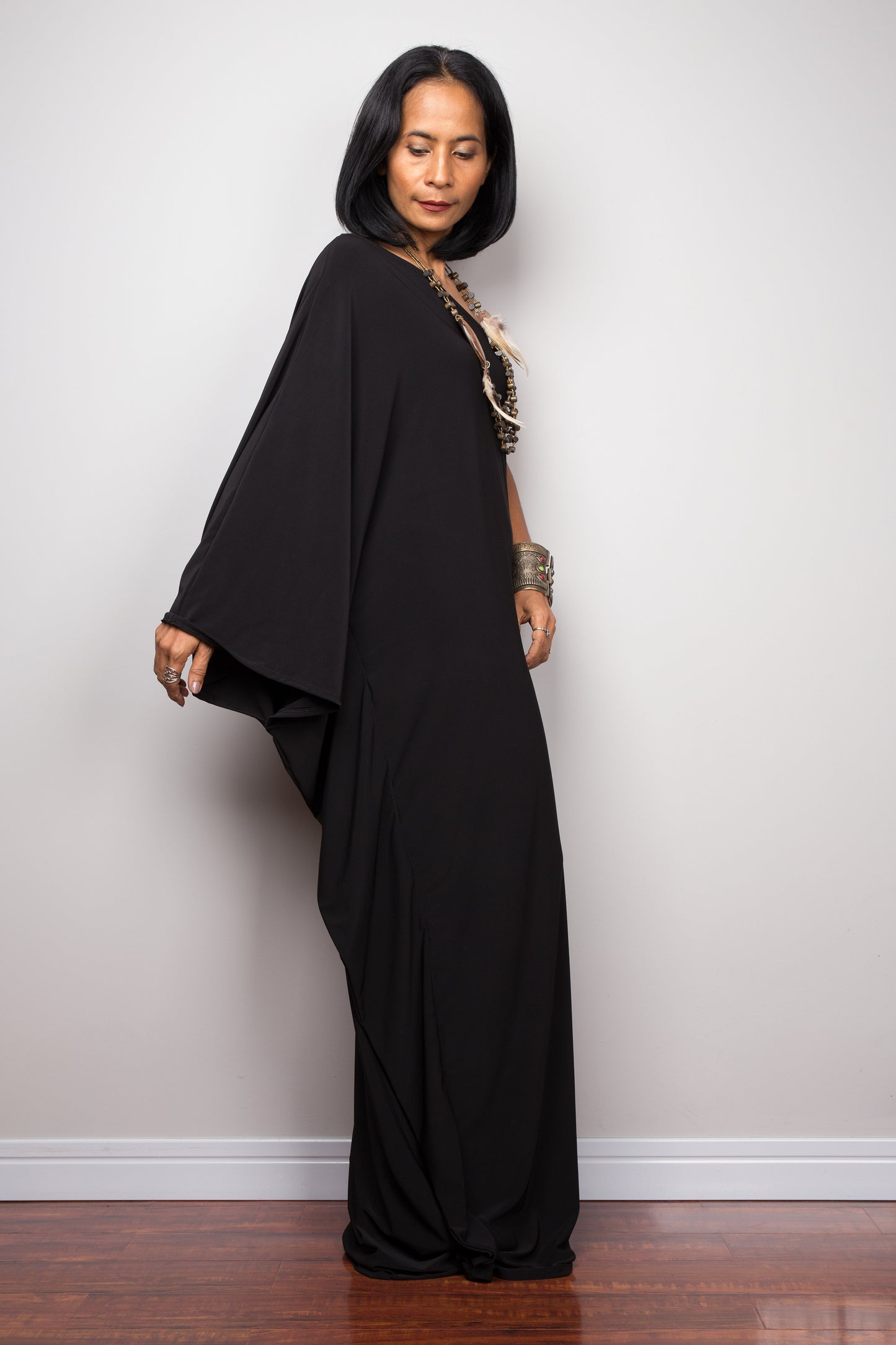 Black one shoulder dress. Side view with extended sleeve