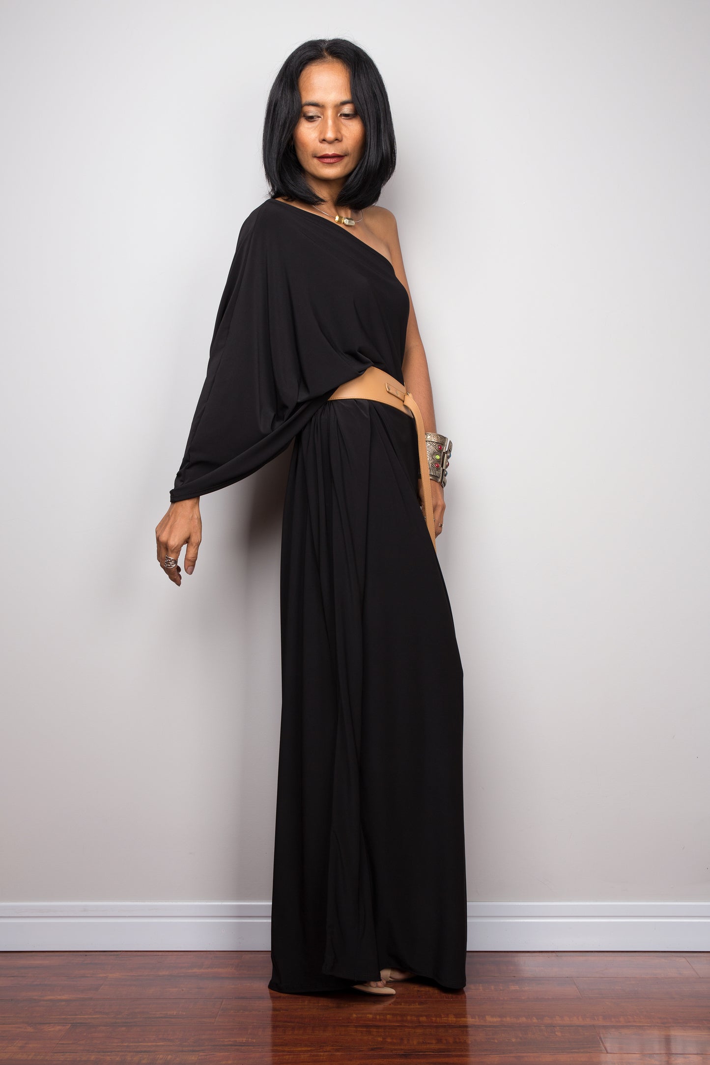 Black one shoulder dress paired with leather belt